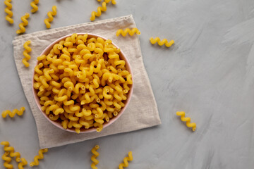 Homemade Organic Dried Riccioli Pasta in a Pink Bowl, top view. Flat lay, overhead, from above.