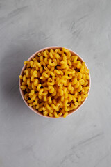 Homemade Organic Dried Riccioli Pasta in a Pink Bowl, top view. Flat lay, overhead, from above.