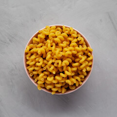Homemade Organic Dried Riccioli Pasta in a Pink Bowl, top view. Flat lay, overhead, from above.