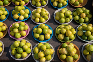  Fresh yellow lemons are displayed for sale In plastic plates,