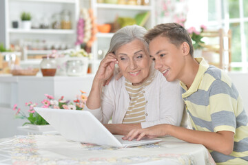 Grandmother with grandson using laptop at home