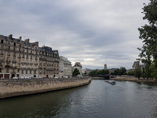 Fototapeta na wymiar Barge at river Seine in Paris with buildings at Ile Saint-Louis