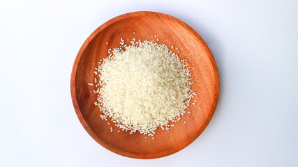 Close up photo rice on wooden plate isolated on white background. Slanted angle.