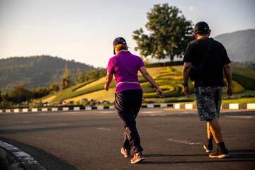 senior couple walking in the park on sunlight in evening day