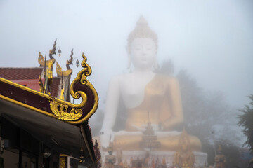 Close up of roof temple at wat Doi khum buddhist statue. Chiang mai, Thailand. .With  the largest bhudda on mist background