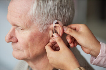 Deaf senior man wearing hearing aid