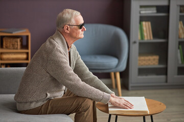 Senior man with blindness reading a book