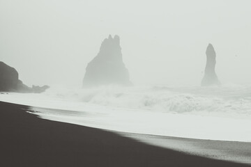 Dramatic Reynisfjara beach monochrome landscape photo. Beautiful nature scenery photography with rocks on background. Idyllic scene. High quality picture for wallpaper, travel blog, magazine, article