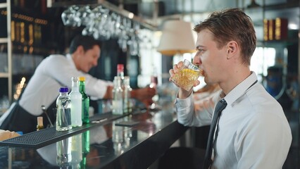 Businessman drinking whiskey in restaurant. Successful boss spending time in place with expensive alcohol