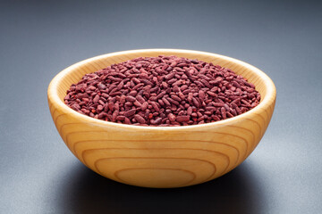 Red yeast rice in a wooden bowl. Chinese traditional food and medicine.