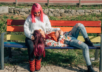 lesbian couple on bench painted gay rainbow relaxed