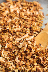 Homemade healthy granola with green buckwheat, coconut flakes, oatmeal, nuts and natural syrup on baking sheet.