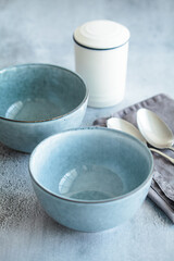 Table setting for dinner. Empty blue bowls for soup or breakfast on gray table.