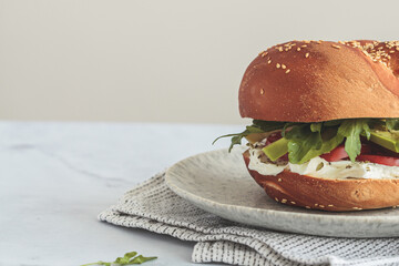 Sandwich with cream cheese, tomato, avocado in wheat bun. Breakfast food concept.