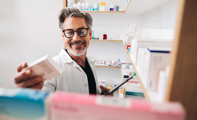 Obraz na płótnie Canvas Pharmacist reading a medication label in a chemist