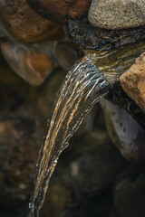 water flows like a waterfall in a stream at the end of rocks and stones
