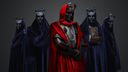 Studio shot of five members of occult brotherhood against gray background.