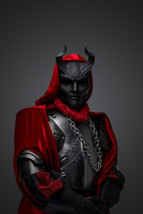 Portrait of dark member of mysterious cult dressed in red robe and black mask.