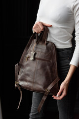 photo of a woman with a brown leather backpack . indoors photo