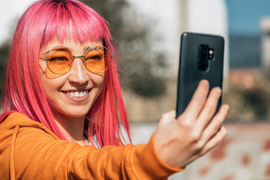 funny urban woman taking a selfie or live video with the phone