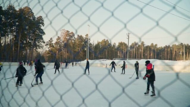 Children play bandy on the hockey rink. An exciting game with passion. Slow motion.