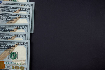 close-up stacks of hundred dollar bills isolated on dark background.