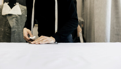 Tailor hands working with measure bar.