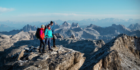 Friends standing at Piz Boe mountain on sunny day, Dolomites, Italy