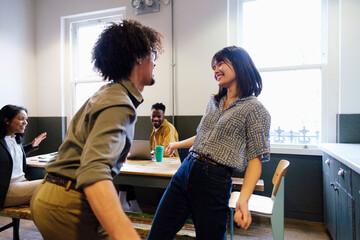 Cheerful business colleagues dancing with each other at office