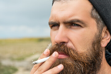 image of man smoking cigarette in the mountain. man smoking cigarette outdoor