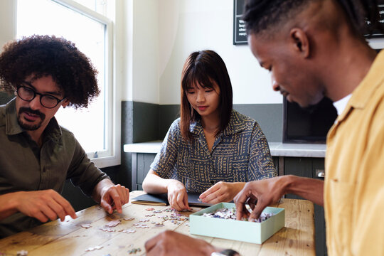 Multiracial business colleagues playing puzzle game at office
