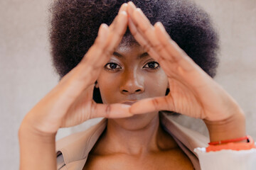 Young woman making triangle gesture with hands