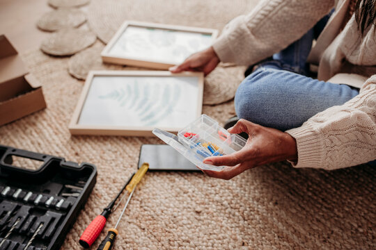 Woman making DIY picture frames sitting at home