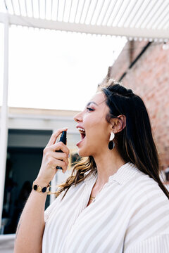 Woman using mouth spray on roof