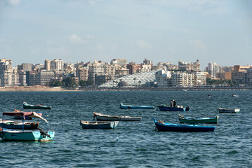 Local fishermen and fishing boats moored in the Mediterranean harbor of the Egyptian Delta port...