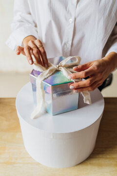 Hands Of Woman Tying Ribbon On Gift