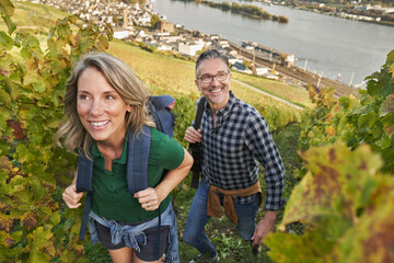Happy couple hiking amidst vineyard