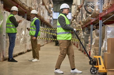 Fototapeta na wymiar Full length shot of three workers doing operations in storage warehouse