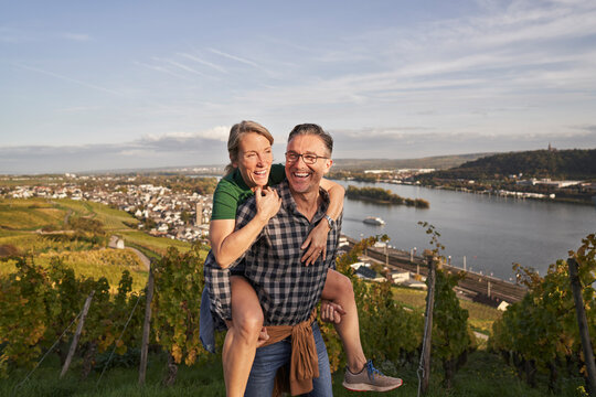 Mature man piggybacking woman under sky