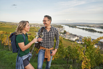 Happy mature couple enjoying wine on hill