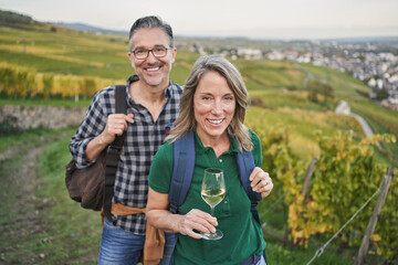 Happy mature couple enjoying wine tasting in vineyard