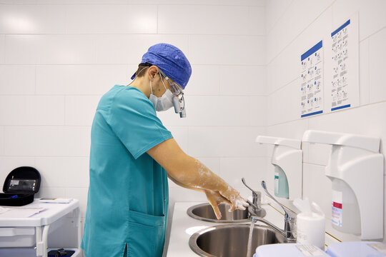 Surgeon Washing Hands In Sink At Hospital