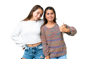 Friends girls over isolated chroma key background giving a thumbs up gesture