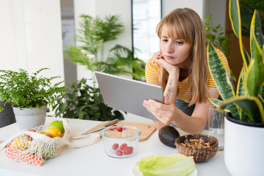 Woman watching tutorial on tablet PC at home