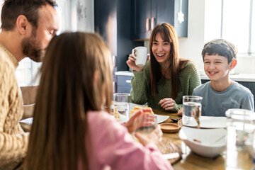 Happy family having breakfast at table