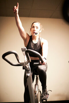 Female fitness instructor on&acirc;&euro;&nbsp;exercise bike