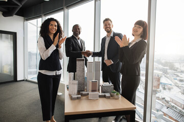Multiethnic businesspeople real estate, agents developers handshake and applauding after successful...