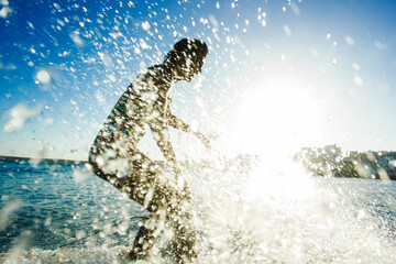 A surfer girl in a bikini surfs a little wave on her longboard during a before sunset session