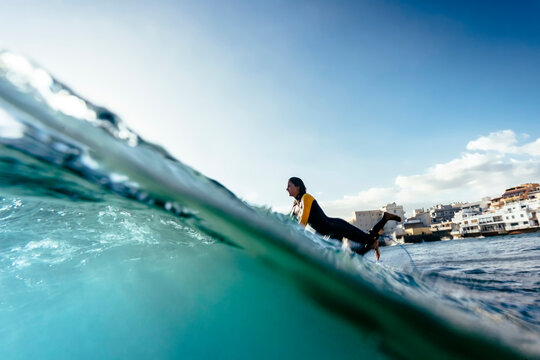 A surfer girl passes over a wave