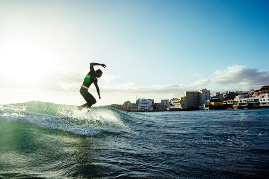 Surfer riding small wave in sea